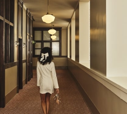 a woman walking through a hallway with no shoes on
