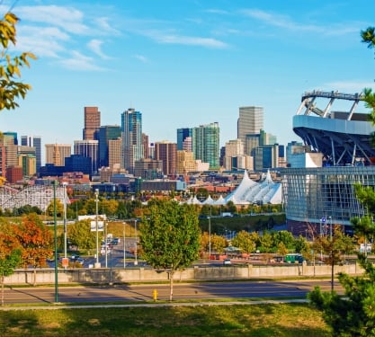 The outside of the Empower Field at Mile High in Denver, Colorado with the city skyline in the background.