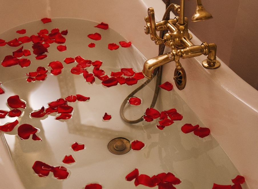 A bathtub filled with rose petals