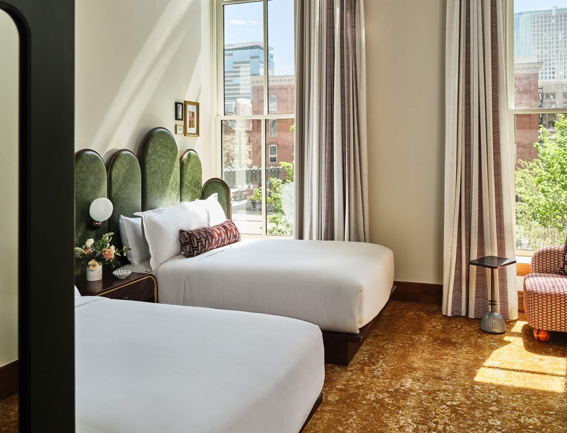 Two queen beds in the Deluxe Classic Guest Room at the Crawford Hotel in Denver, Colorado.