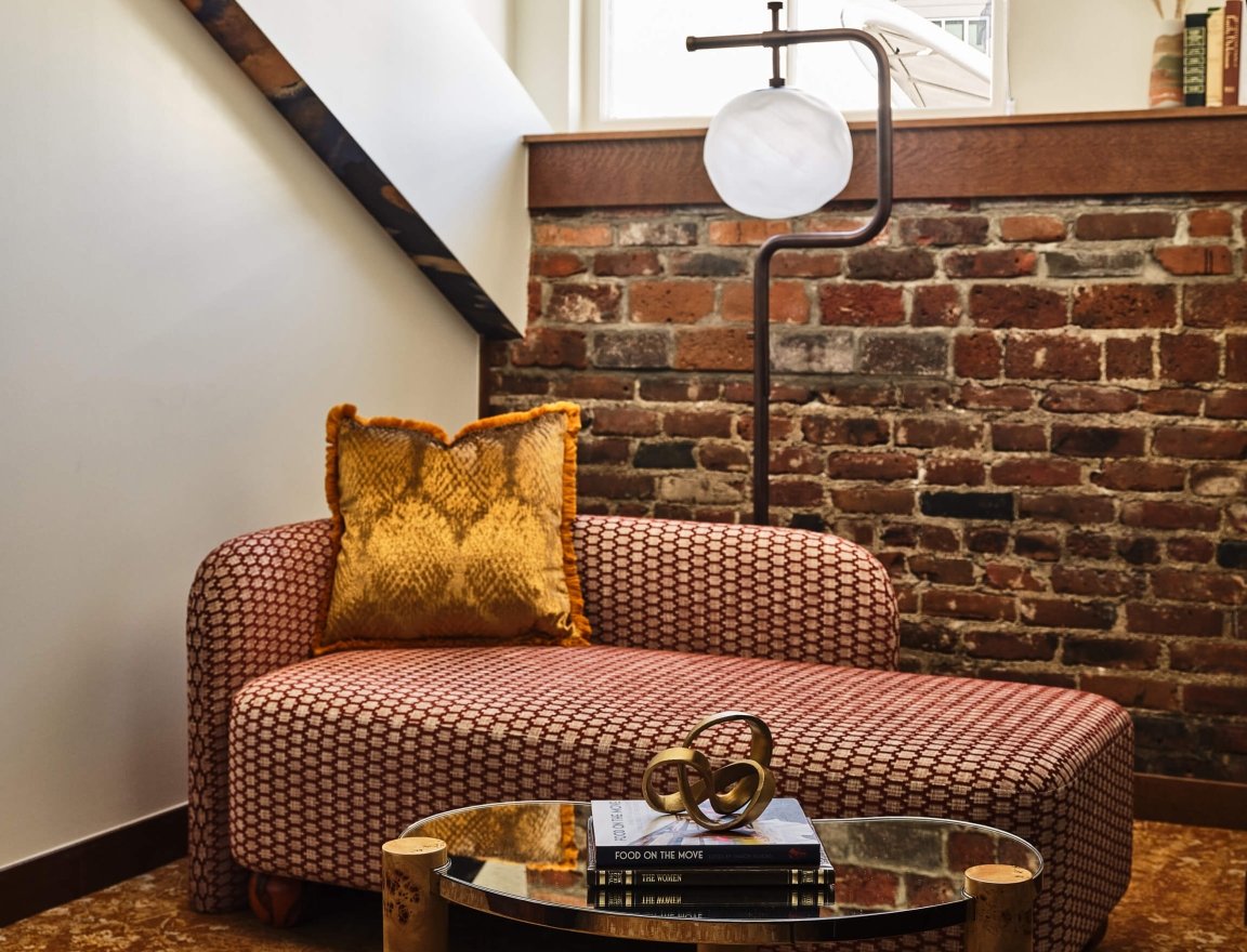 Seating area with a chaise lounge in the Superior Loft Guest Room at the Crawford Hotel in Denver, Colorado.