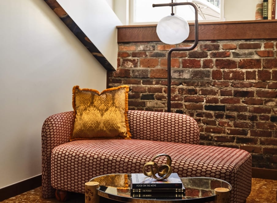 Seating area with a chaise lounge in the Superior Loft Guest Room at the Crawford Hotel in Denver, Colorado.