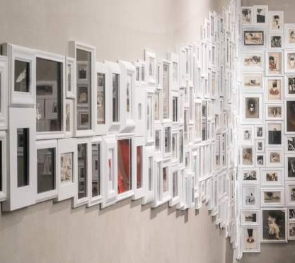 A woman admires art on a gallery wall.