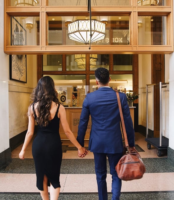 A couple walking up to the main desk at the Crawford Hotel in Denver, Colorado.