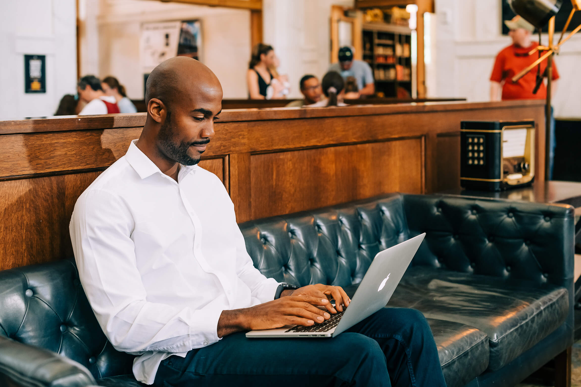 A man works on his laptop on a couch in Union Station.