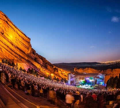 A concert taking place at dusk at Red Rocks Amphitheatre in Colorado.