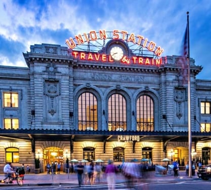 The exterior of the Crawford Hotel at sunset with people bustling by.