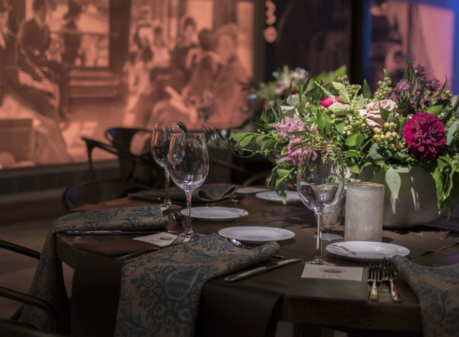 A table set with glassware, tableware and an elegant bouquet of flowers in Webb Gallery at the Crawford Hotel in Denver, Colorado.