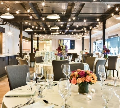 Tables set with glassware, tableware and an elegant bouquet of flowers in Webb Gallery at the Crawford Hotel in Denver, Colorado.