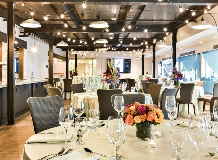 Tables set with glassware, tableware and an elegant bouquet of flowers in Webb Gallery at the Crawford Hotel in Denver, Colorado.