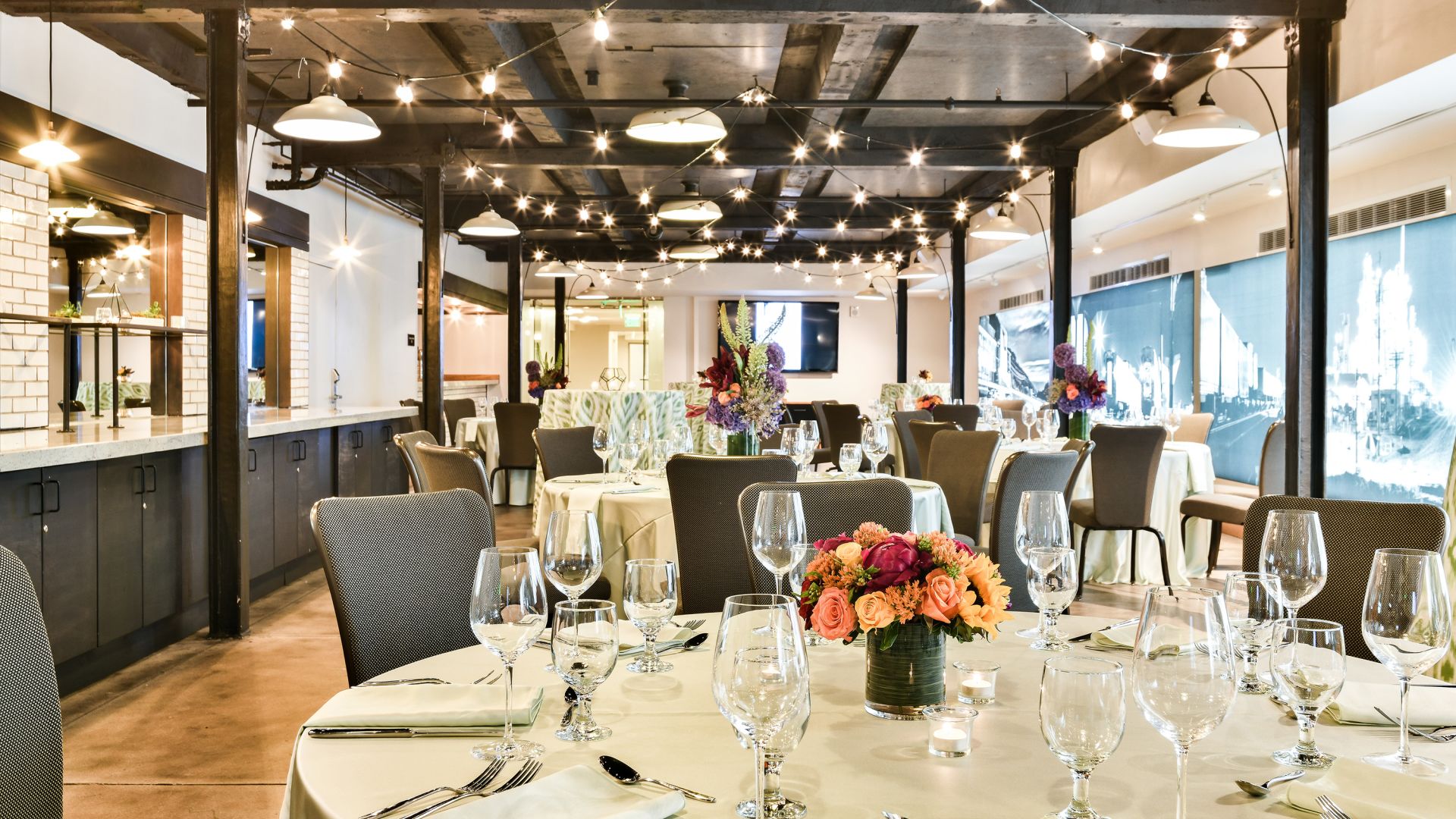 Tables set with glassware, tableware and an elegant bouquet of flowers in Webb Gallery at the Crawford Hotel in Denver, Colorado.