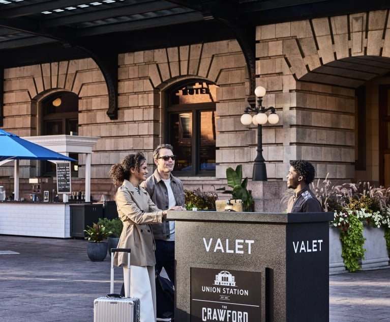 a man nd woman speaking to a valet worker outside denver union station