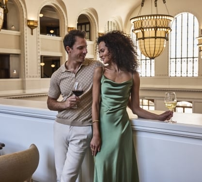 a man and woman standing infront of a ledge smiling