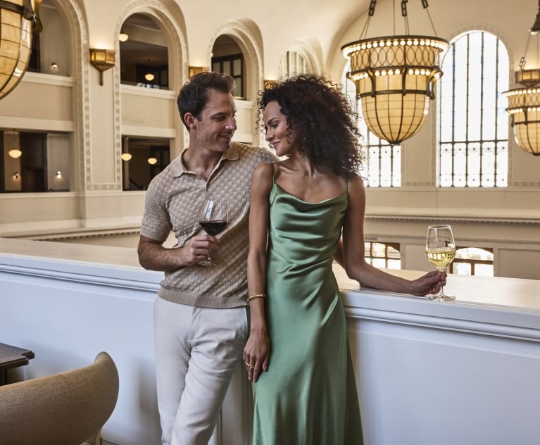 a man and woman standing infront of a ledge smiling