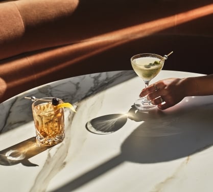 a close up of two cocktails sitting on a table