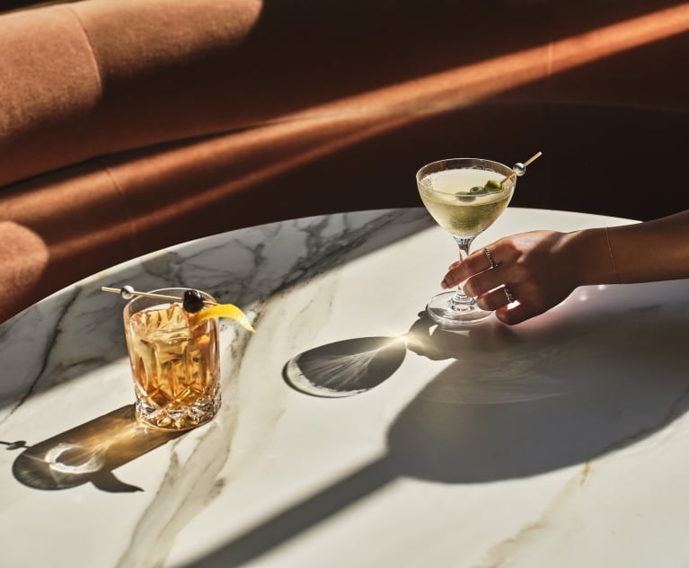 a close up of two cocktails sitting on a table