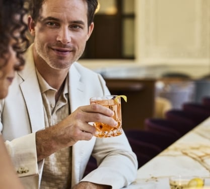 Close up of a man and a woman talking and enjoying drinks