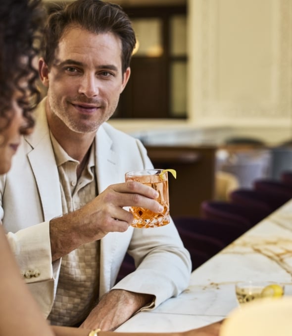 Close up of a man and a woman talking and enjoying drinks