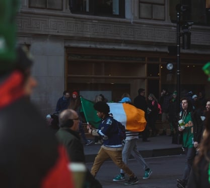 Crowds of people walking down the street to celebrate st patricks day