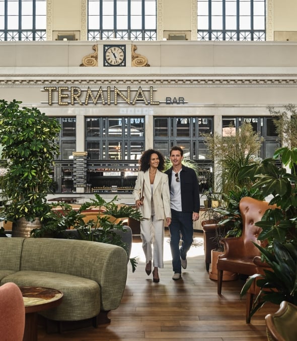 A man and woman walking through the seating area at Terminal Bar at Denver Union Station