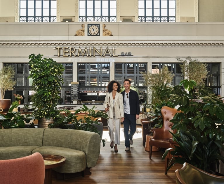 A man and woman walking through the seating area at Terminal Bar at Denver Union Station