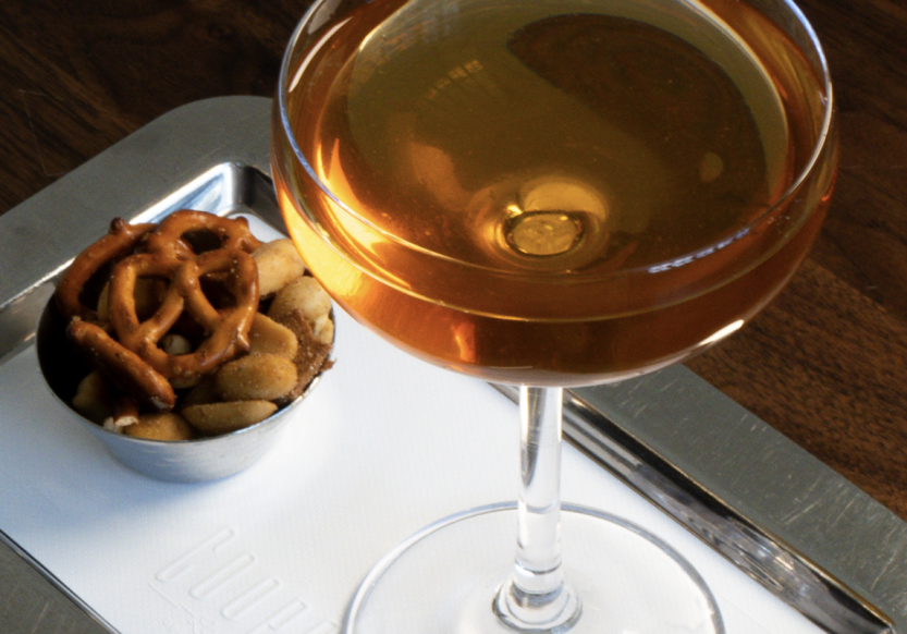 An orange cocktail and pretzels from The Cooper Lounge