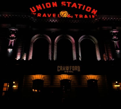 Exterior of Union Station in Denver lit with red and orange lighting for Halloween