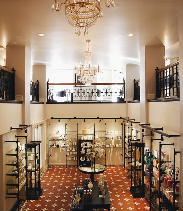 a room with chandeliers hanging from the roof and shelves of wellness products below