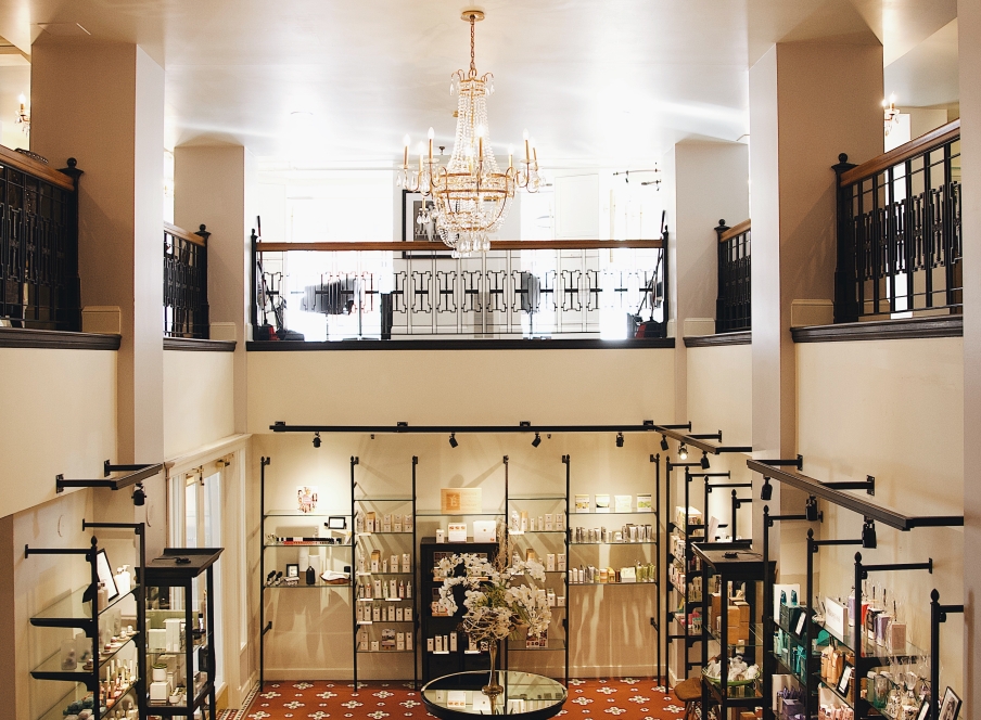 a room with chandeliers hanging from the roof and shelves of wellness products below