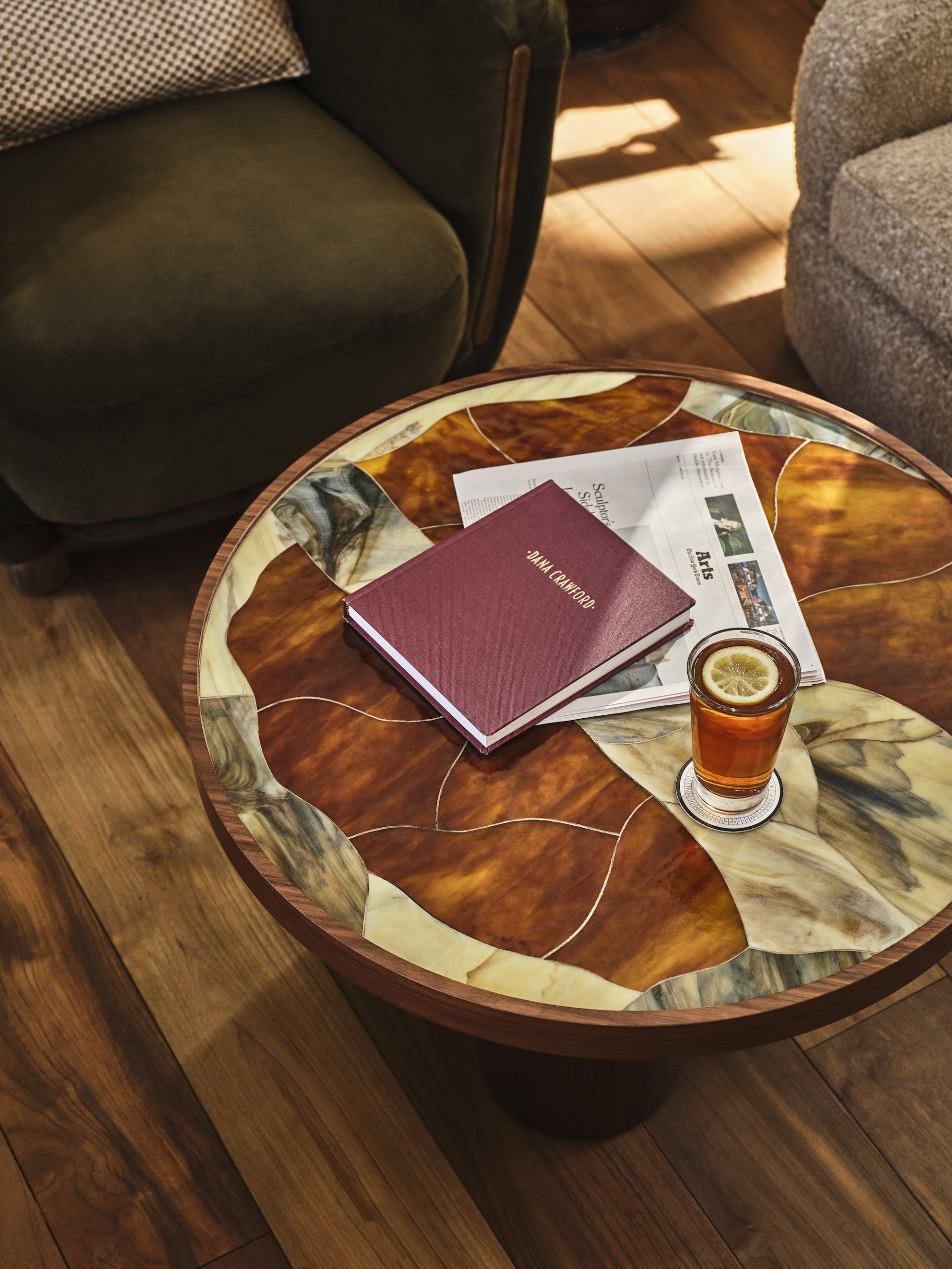 a book and news paper sitting next to a drink