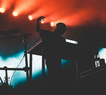 A dj playing the keyboard in an electro pop concert